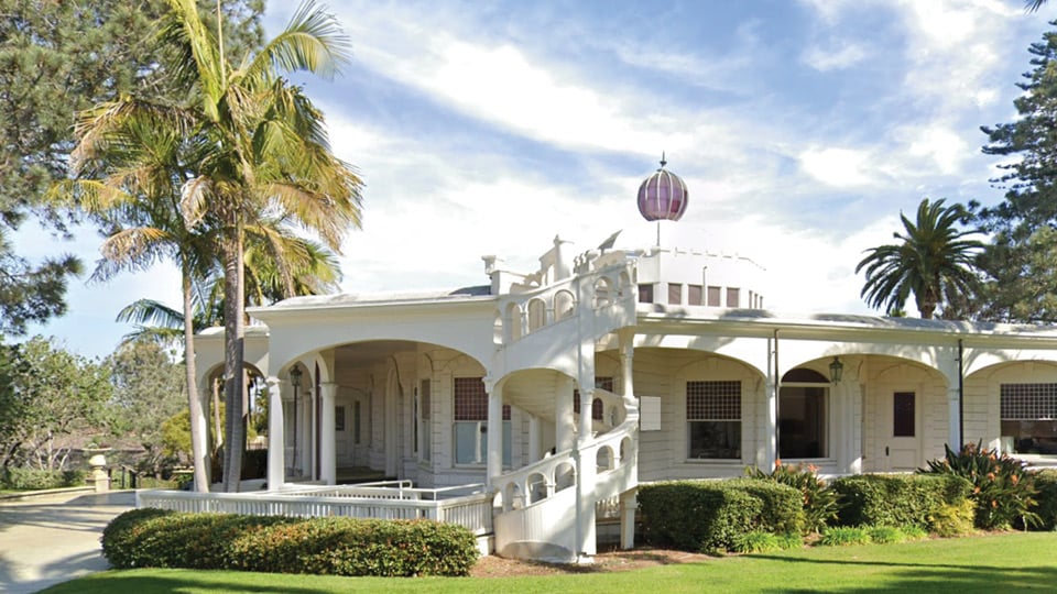 Point Loma one story white building with arches in setting with green palm trees