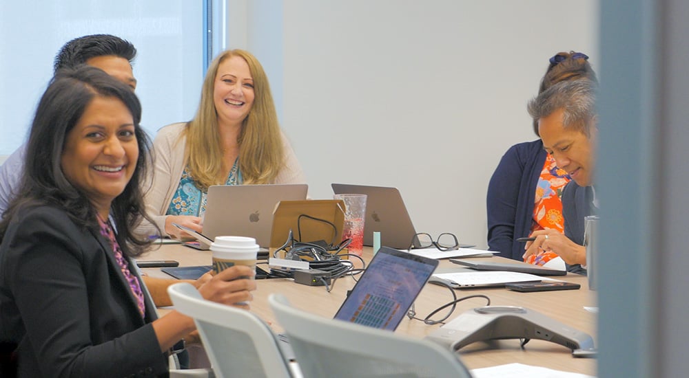 WellRight CEO with others in a conference room, smiling