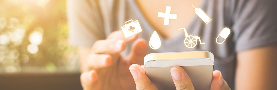 Close up of woman holding a cell phone with medical icons floating around the phone