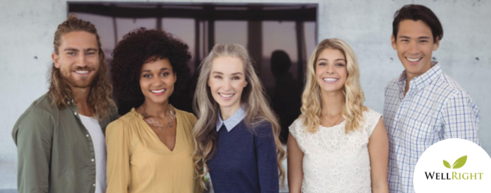 Five, twenty-something age people stand shoulder-to-shoulder, facing the camera and smiling