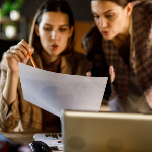 two-professionals-discuss-document-in-hand