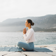 woman-practicing-yoga-in-front-of-lake-and-mountain