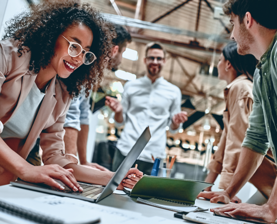 woman-smiling-at-computer-with-work-group