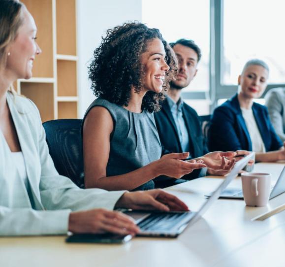 Four HR professionsals, three female and one male, sitting a conference room having a discussion